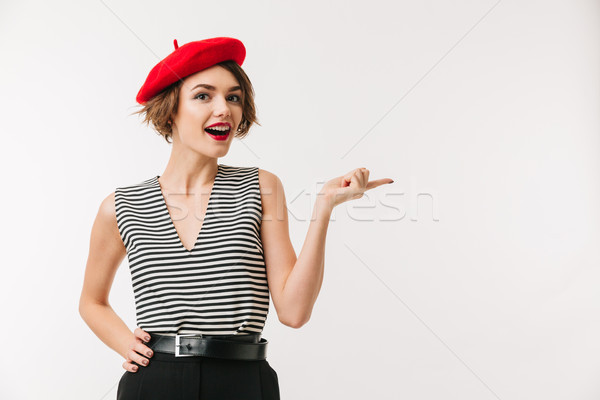 Portrait of a cheerful woman wearing red beret pointing Stock photo © deandrobot