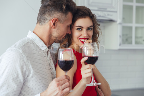 Stock photo: Young man kiss his beautiful smiling woman while drinking wine