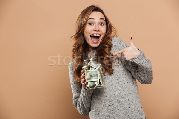 Happy attractive brunette girl in gray woolen sweater pointing w Stock photo © deandrobot