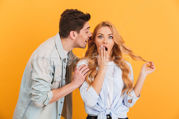 Image of brunette man whispering secret or interesting gossip to Stock photo © deandrobot