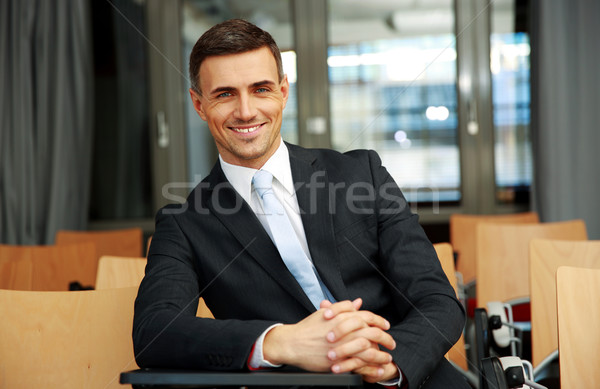 Happy businessman standing at conference hall Stock photo © deandrobot
