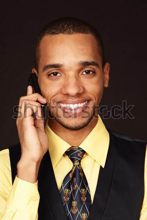 Closeup portrait of a young african-american businessman over dark background Stock photo © deandrobot