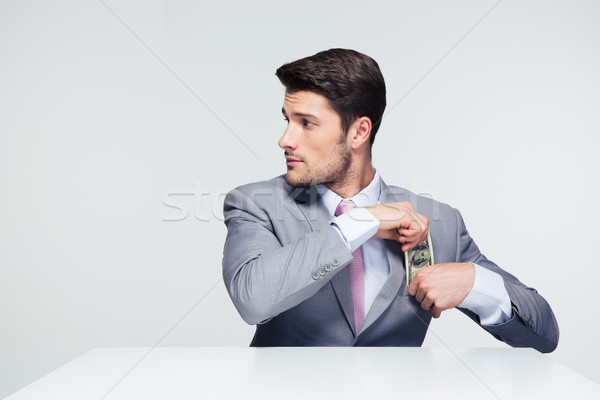 Businessman putting money in pocket Stock photo © deandrobot