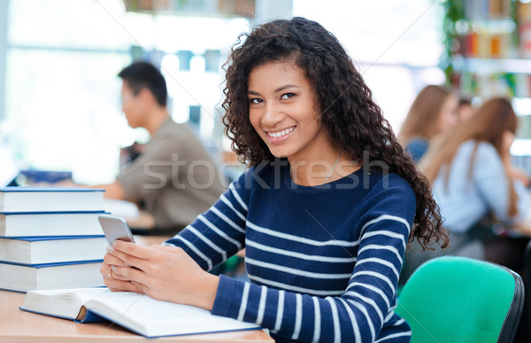 Stock photo: Woman sitting at the table with smartphone