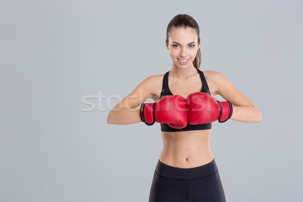 Beautiful smiling young fitness woman wears red boxing gloves  Stock photo © deandrobot