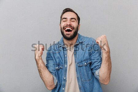 Excited elated happy bearded young male celebrating success Stock photo © deandrobot