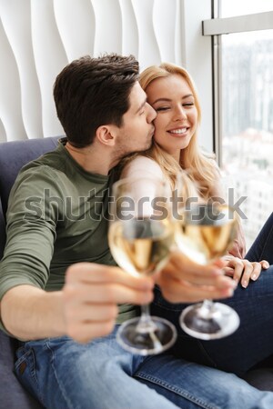 Happy couple drinking red wine and flirting at home Stock photo © deandrobot