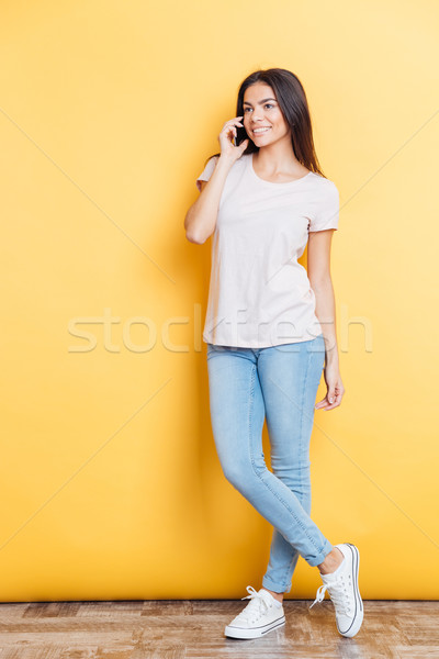 Happy woman talking on the phone and looking away Stock photo © deandrobot