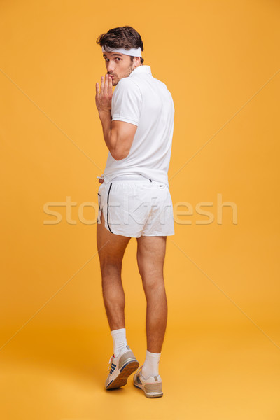 Stock photo: Back view of funny shy young sportsman posing and grimacing