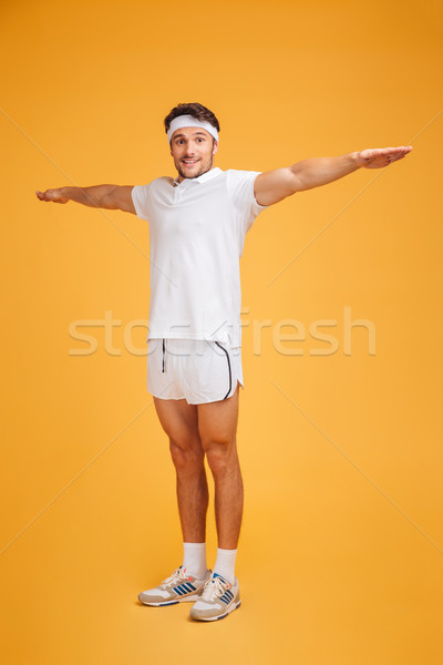 Happy young sportsman standing and doing exercises Stock photo © deandrobot
