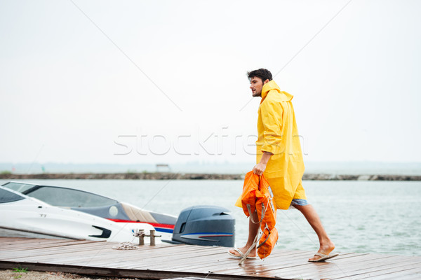 Side view of a sailor holding life vest at pier Stock photo © deandrobot