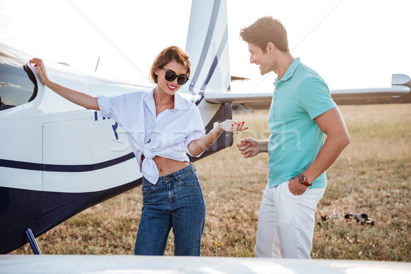 Couple standing and talking on the field near small airplane Stock photo © deandrobot