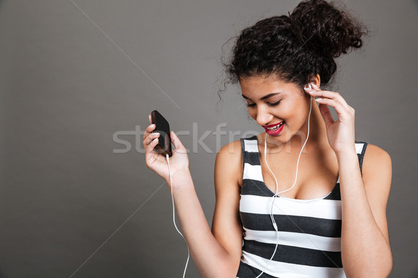 Stock photo: Woman listening to music and using earphones