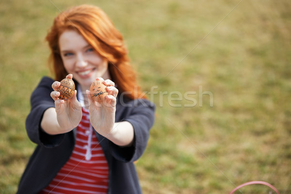 Girl with long ginger hair showing two painted easter eggs Stock photo © deandrobot