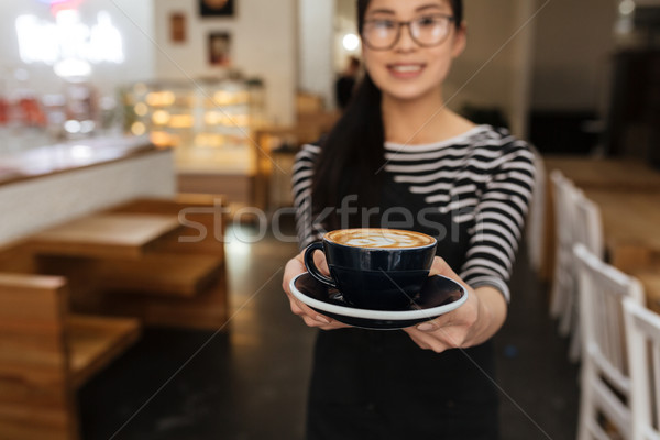 Asian barmaid extends the cup of coffee Stock photo © deandrobot