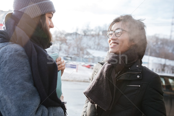 Asian man wearing glasses and scarf with caucasian lady talking Stock photo © deandrobot