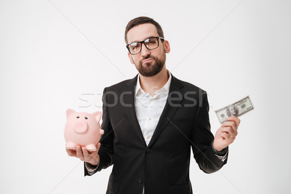Sad businessman showing money and holding moneybox. Stock photo © deandrobot