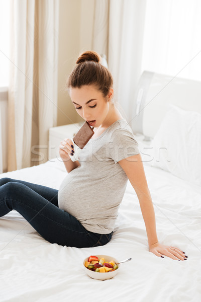 Töprengő terhes nő választ csokoládé szelet gyümölcssaláta terhes Stock fotó © deandrobot