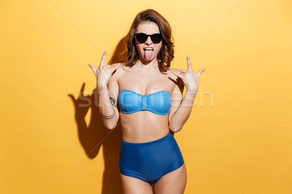 Screaming young woman in swimwear make rock gesture. Stock photo © deandrobot