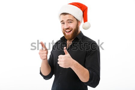Happy man in shirt and christmas hat showing thumbs up Stock photo © deandrobot