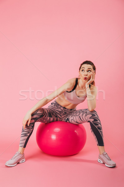 Vertical image of Mystery sportswoman sitting on fitness ball Stock photo © deandrobot