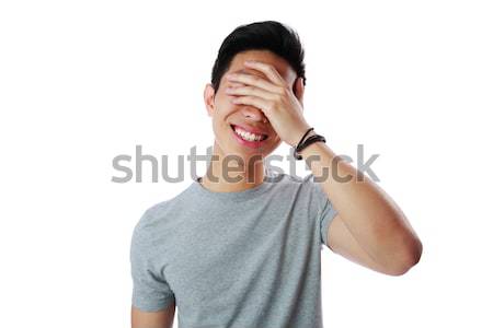 Portrait of a young man covering his eyes with his hand over white background Stock photo © deandrobot