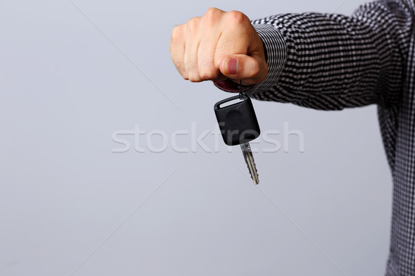 Hand holding car keys isolated on gray background Stock photo © deandrobot