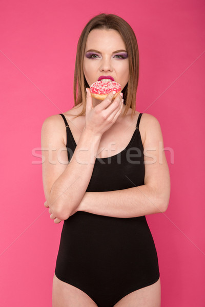 ストックフォト: 魅力的な · 若い女性 · 食べ · ドーナツ · ピンク · 小さな
