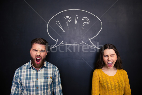 Angry youple shouting over blackboard background Stock photo © deandrobot