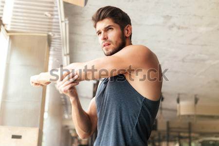 Stock photo: Sportsman sitting on pier and using smartphone