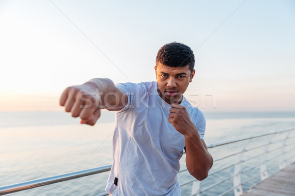 Focused african man athlete doing boxing training in the morning Stock photo © deandrobot
