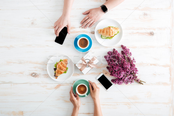 手 情侶 飲用水 咖啡 羊角麵包 木桌 商業照片 © deandrobot