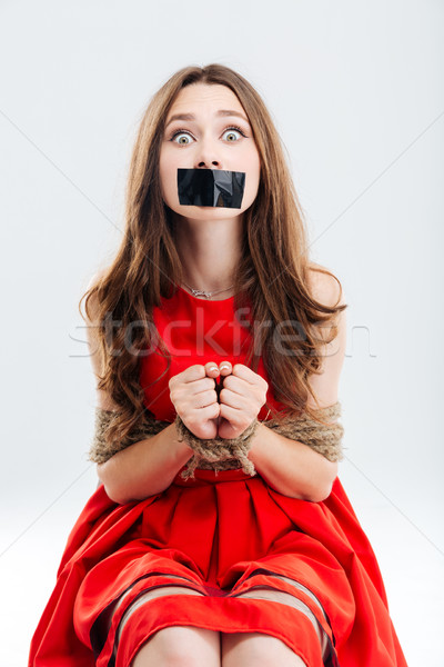 Woman bounded using ropes sitting with closed mouth by tape Stock photo © deandrobot