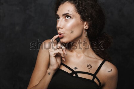 Beautiful african young woman with stylish makeup sitting on chair Stock photo © deandrobot