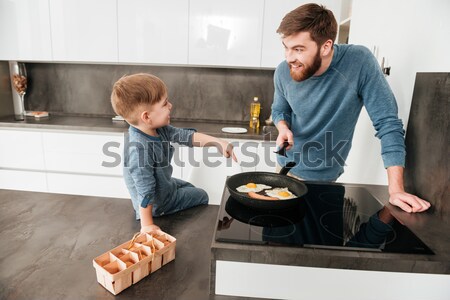 Father cooking at kitchen with his little cute son Stock photo © deandrobot