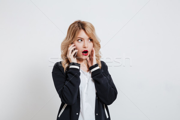 [[stock_photo]]: étonné · jeune · femme · parler · téléphone · isolé · blanche