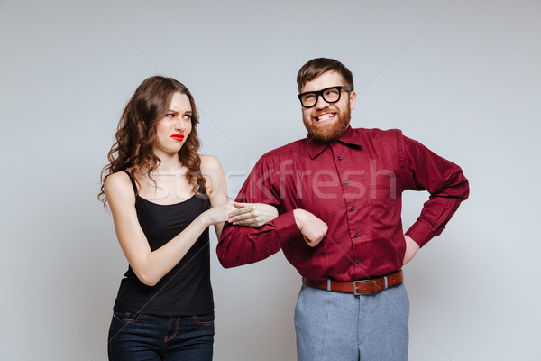 Displeased woman holding hand of Male nerd Stock photo © deandrobot