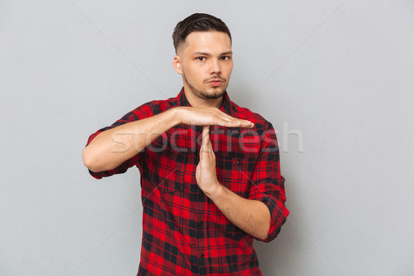 Serious man showing time-out gesture Stock photo © deandrobot