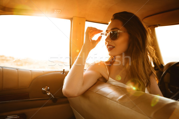 Gyönyörű fiatal nő napszemüveg ül elöl ülés Stock fotó © deandrobot