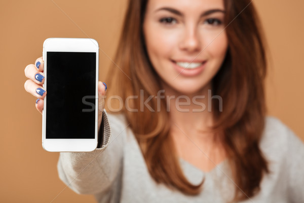 Cropped photo of cheerful brunette woman showing blank screen mo Stock photo © deandrobot
