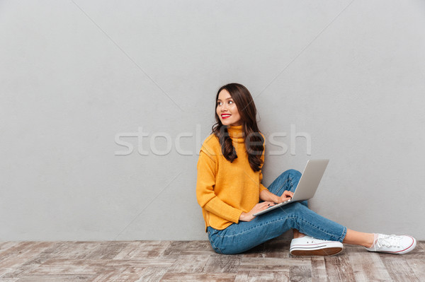 Side view of happy brunette woman sitting on the floor Stock photo © deandrobot