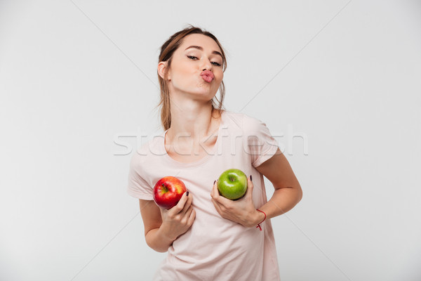 Stock photo: Portrait of a funny girl holding apples at her chest