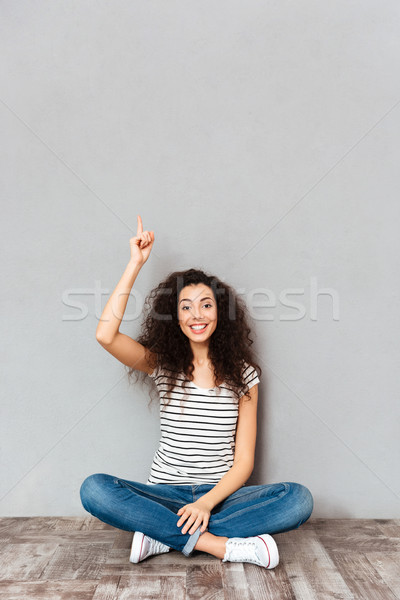 Idee drăguţ femeie parul inchis la culoare şedinţei picioarele incrucisate Imagine de stoc © deandrobot