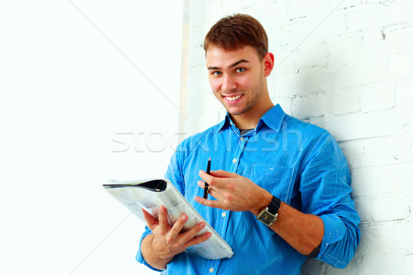 Jovem feliz estudante em pé dobrador parede Foto stock © deandrobot