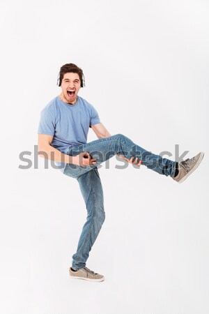 Happy sports man stretching on the mat over white background Stock photo © deandrobot