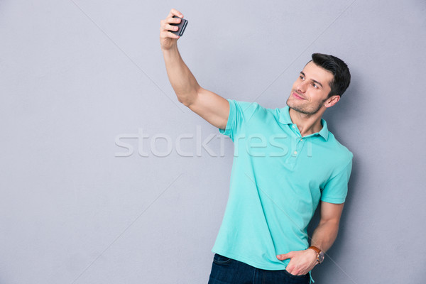 Young man making selfie photo on smartphone Stock photo © deandrobot