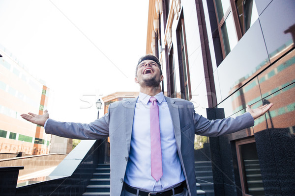 Businessman celebrating his success outdoors Stock photo © deandrobot