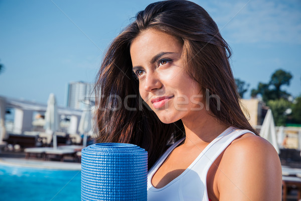 Woman holding yoga mat outdoors Stock photo © deandrobot