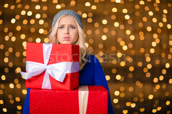 Woman holding gift boxes over holidays lights background Stock photo © deandrobot