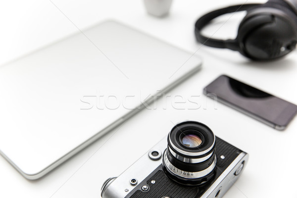 Stock photo: Laptop, blank screen smartphone, old camera, and headphones 